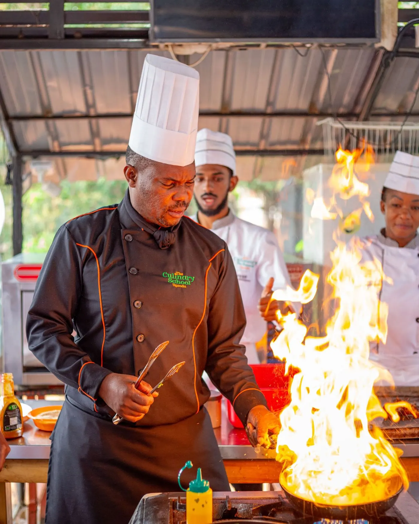 Chef cuisinant au-dessus des flammes dans la cuisine d’un restaurant